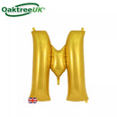 Gold Oaktree foil balloon in the shape of the letter M, 34 inches tall, shiny metallic finish, perfect for celebrations.